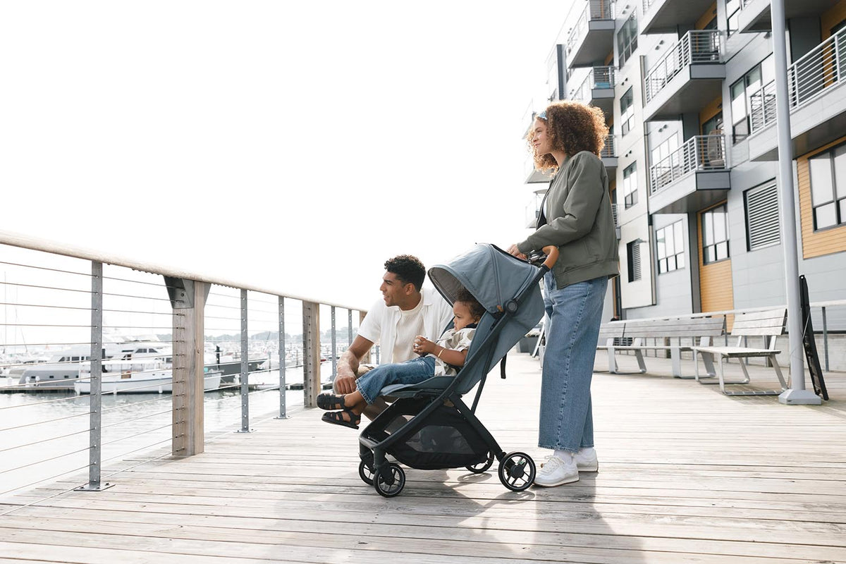 A family walking on a boardwalk with an UPPAbaby Minu V3