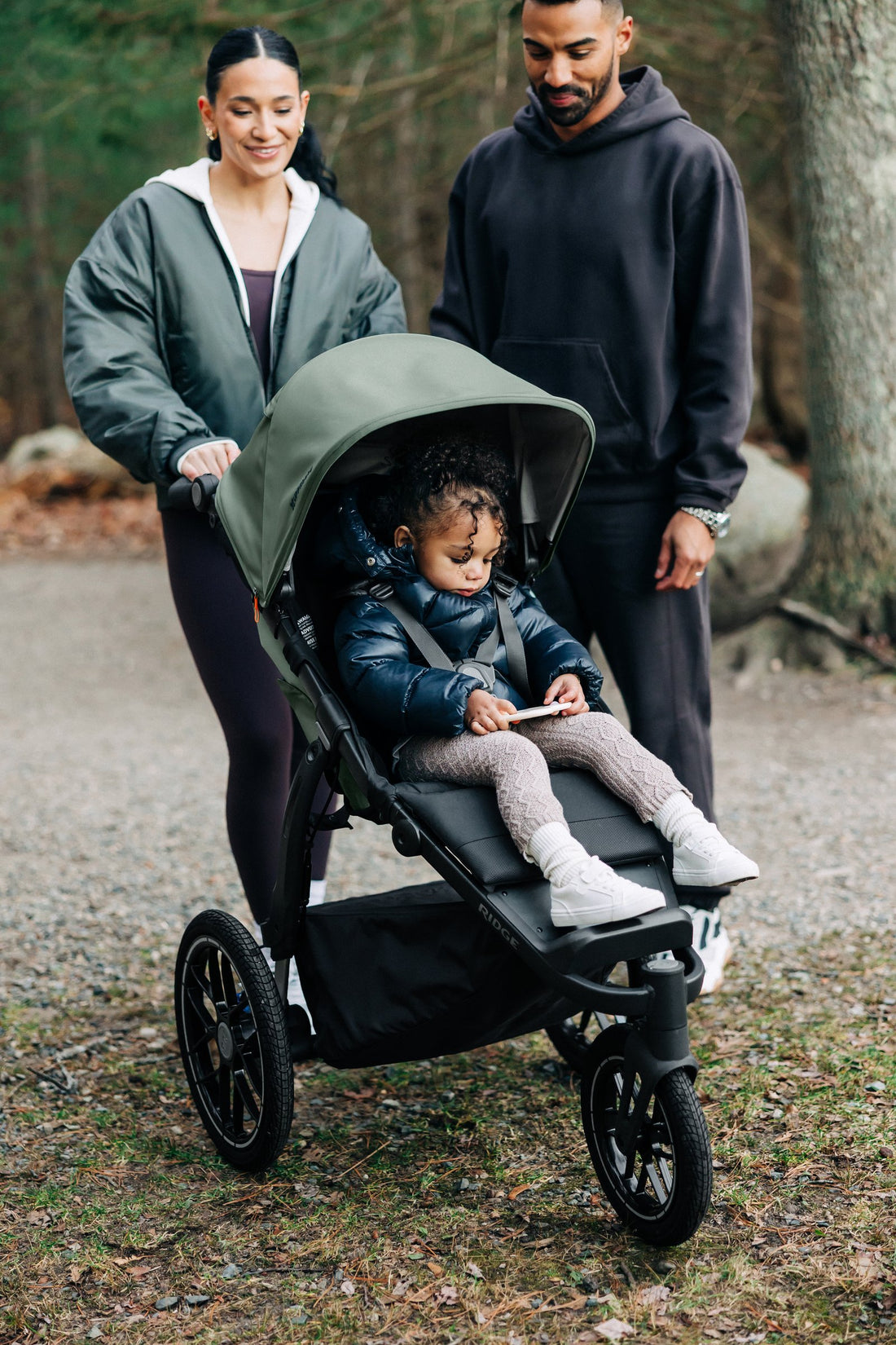 UPPAbaby Ridge V2 Pram Jogger in Evelyn (Meadow Green), on a trail with a toddler in the seat