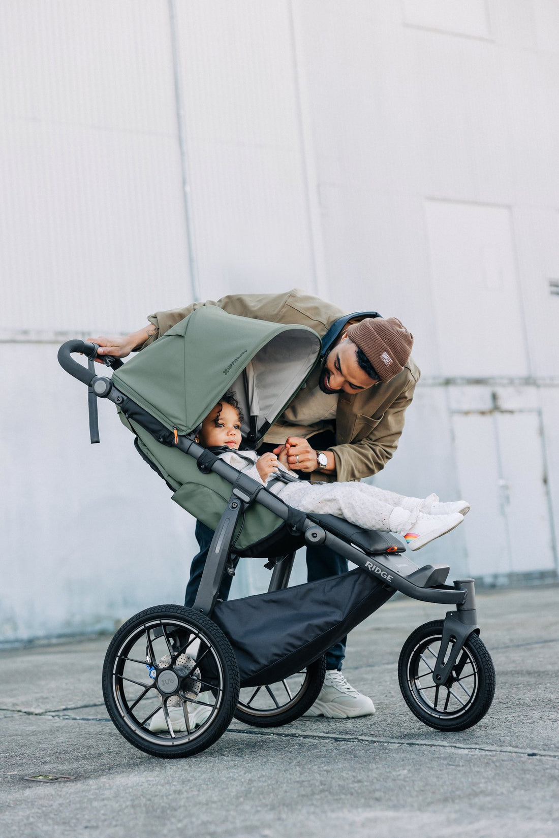 UPPAbaby Ridge V2 Pram Jogger in Evelyn (Meadow Green), checking on a child in the seat